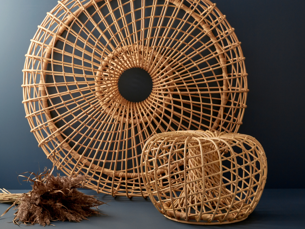 Rattan wall decor and woven rattan basket displayed against a dark blue wall
